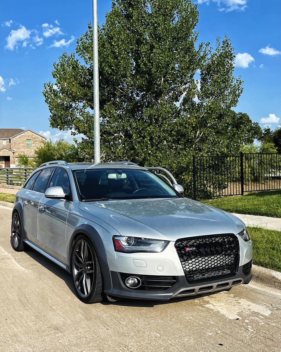 Silver wagon lowered on dark alloy wheels, parked on a suburban street